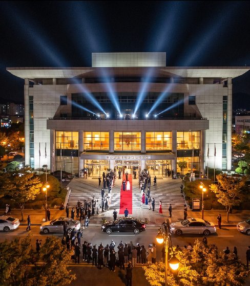 Opening night performer on the Korea Drama Festival 2026 outdoor stage at Namgang Dunchi, Jinju, with the river illuminated in the background
