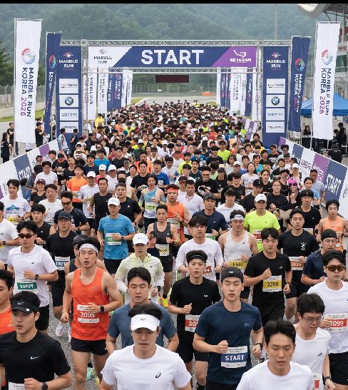 마블런 코리아 2026 인제스피디움 풀서킷 완주 후 한정판 메달을 든 참가자 기념 사진
